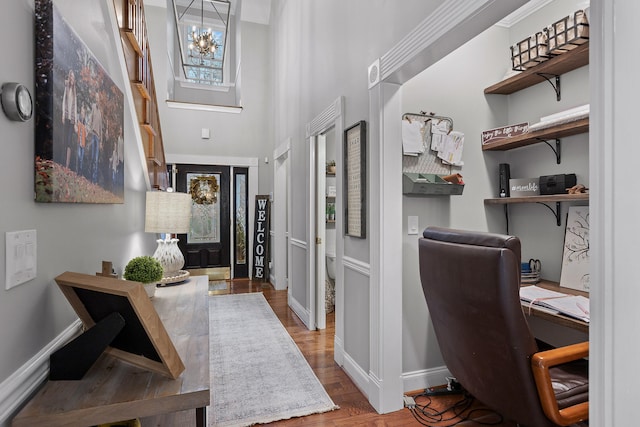 entrance foyer with a high ceiling, hardwood / wood-style floors, and an inviting chandelier