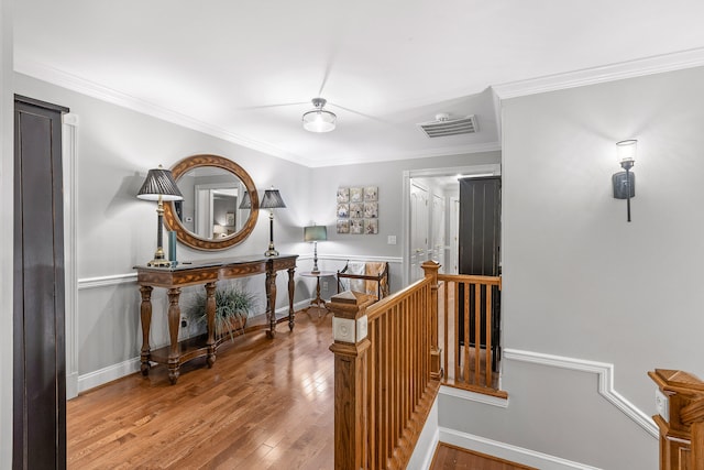 corridor with ornamental molding and hardwood / wood-style floors