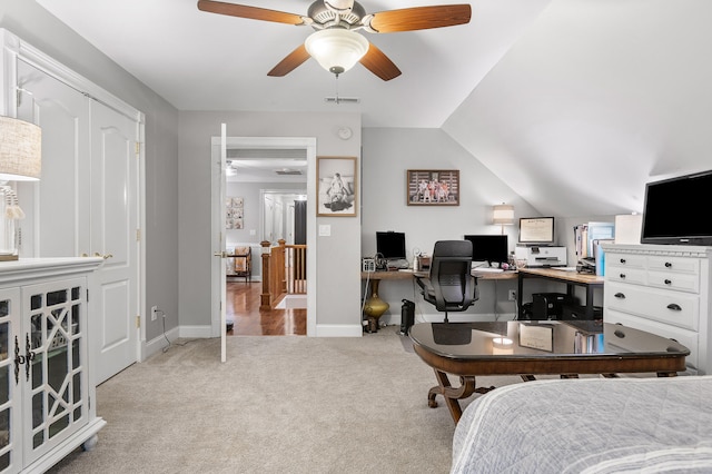 bedroom with a closet, ceiling fan, light colored carpet, and vaulted ceiling