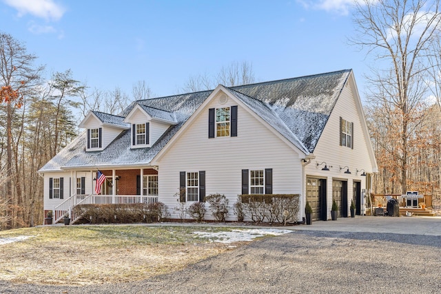 cape cod-style house featuring a porch and a garage