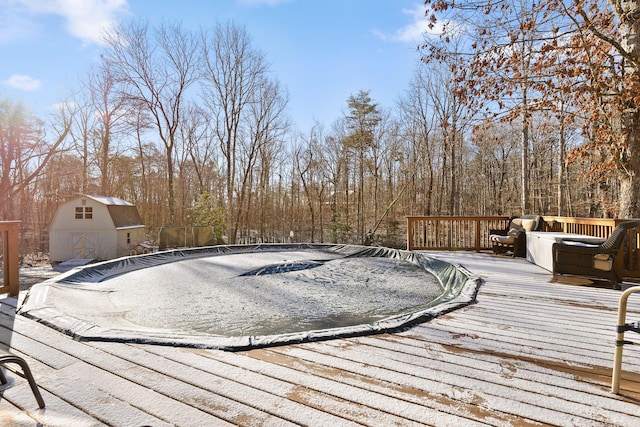 view of pool featuring a deck and a shed