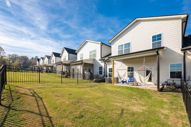 rear view of property featuring a lawn and a patio