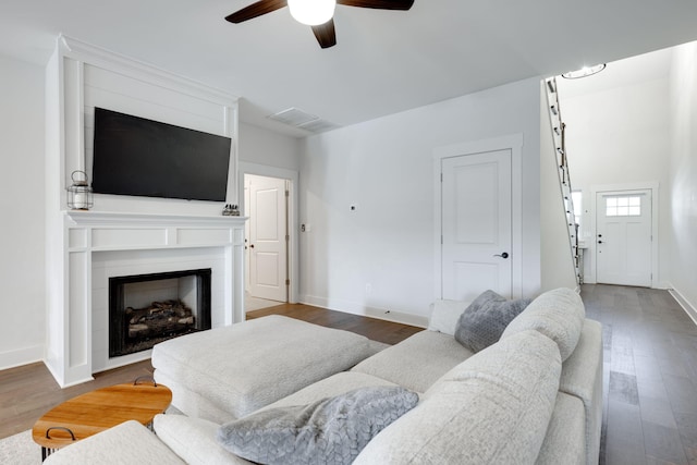 living room with ceiling fan and dark wood-type flooring