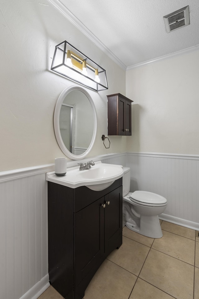 bathroom with ornamental molding, a textured ceiling, vanity, tile patterned flooring, and toilet