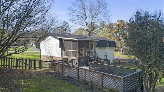 back of house with a sunroom and a yard