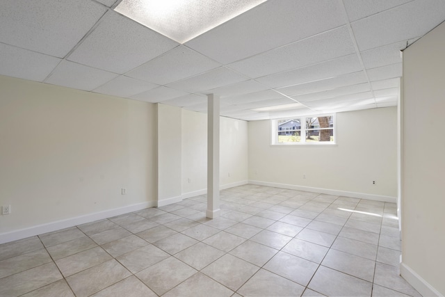 basement with a drop ceiling and light tile patterned floors