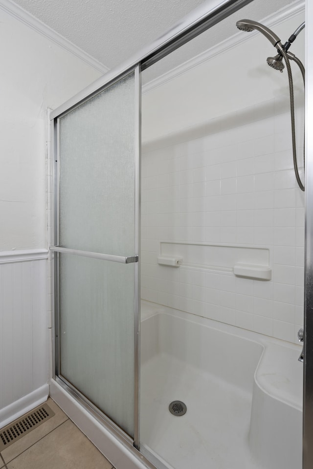 bathroom featuring a textured ceiling, tile patterned floors, walk in shower, and wood walls