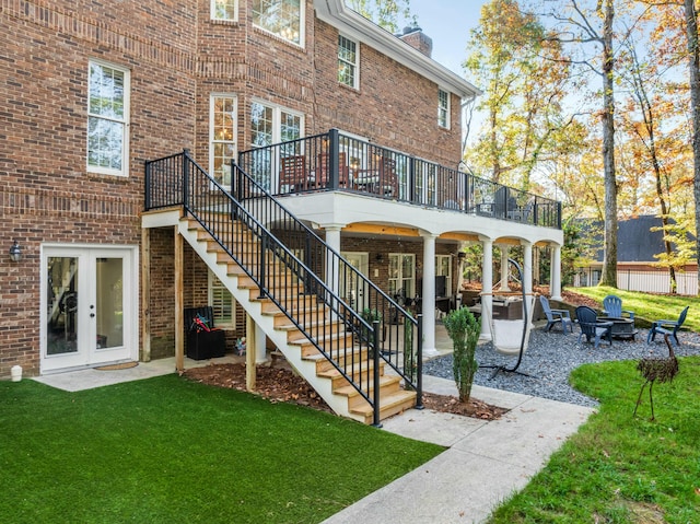 back of property featuring a lawn, a patio area, and an outdoor fire pit