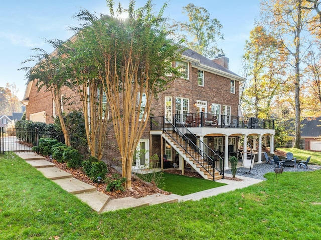 rear view of property with a patio, a wooden deck, and a lawn