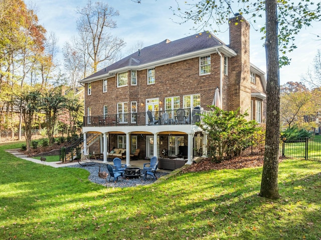 back of property with a yard, an outdoor living space with a fire pit, a patio area, and a wooden deck