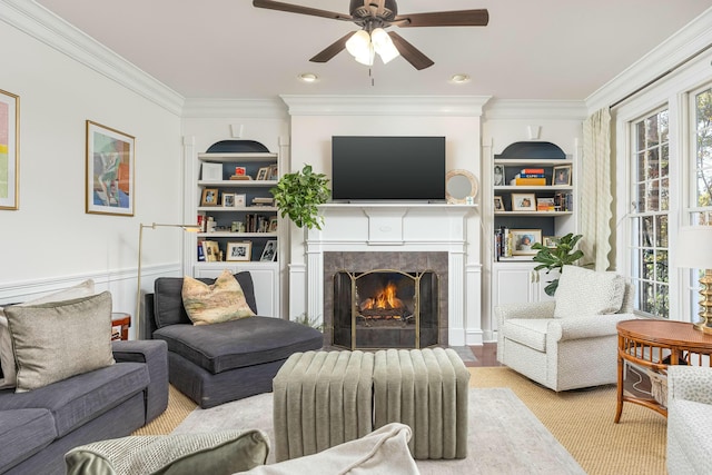 living room with a tile fireplace, a healthy amount of sunlight, and ornamental molding