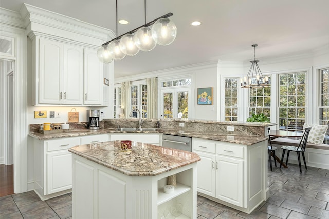 kitchen featuring kitchen peninsula, white cabinets, a kitchen island, and a wealth of natural light