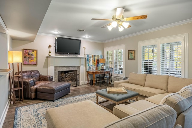 living room featuring a tile fireplace, ceiling fan, ornamental molding, and hardwood / wood-style flooring