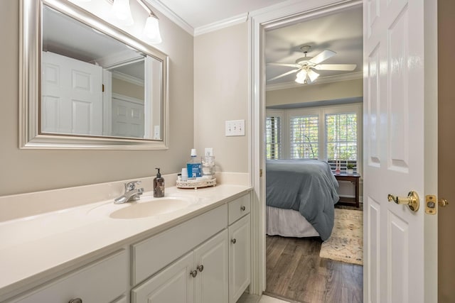 bathroom featuring hardwood / wood-style floors, vanity, ceiling fan, and crown molding