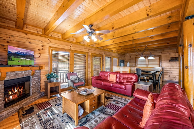 living room with hardwood / wood-style floors, ceiling fan, wooden walls, and beam ceiling