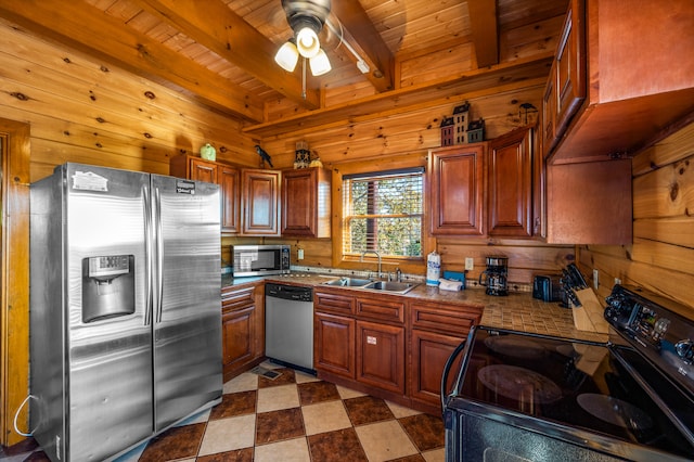 kitchen with sink, wooden walls, appliances with stainless steel finishes, beam ceiling, and wood ceiling