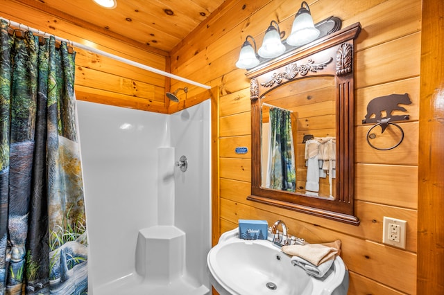 bathroom featuring wooden walls, sink, and a shower with shower curtain