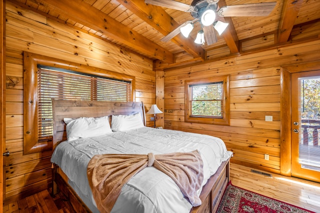 bedroom with beamed ceiling, hardwood / wood-style floors, and ceiling fan