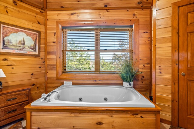 bathroom featuring a bathing tub and wood walls