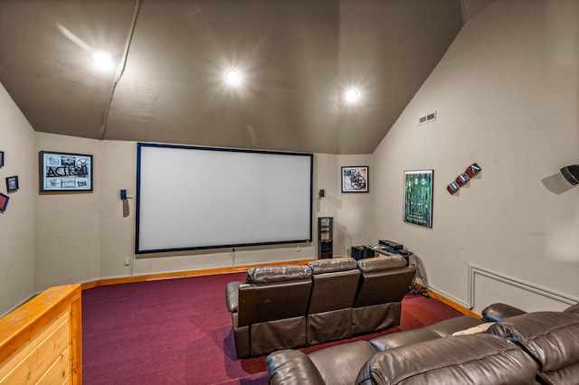 carpeted home theater featuring lofted ceiling