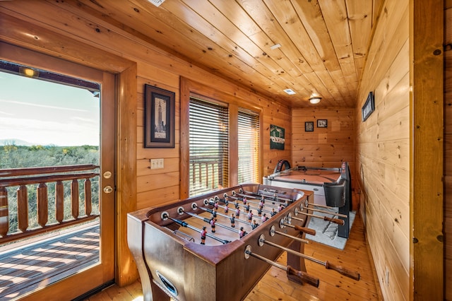 playroom with wood walls, light hardwood / wood-style floors, and wooden ceiling