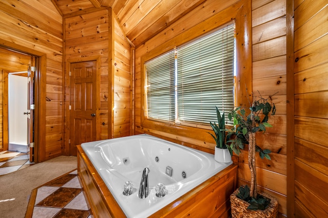 bathroom featuring a tub to relax in, wooden walls, tile patterned flooring, and vaulted ceiling