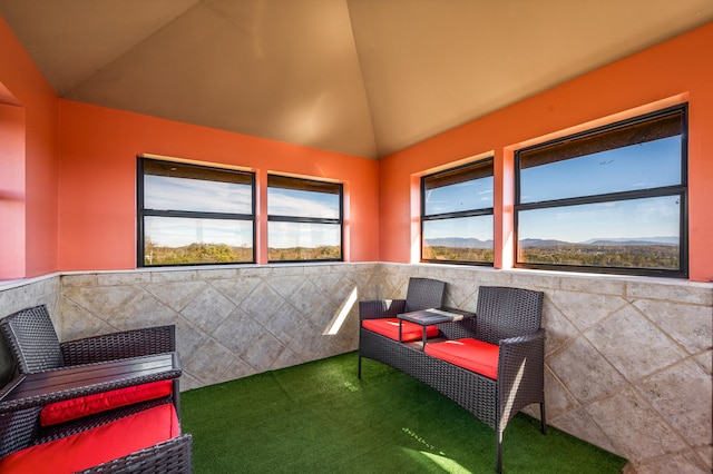 sitting room featuring vaulted ceiling, a mountain view, carpet, and tile walls