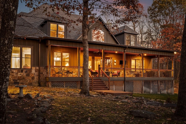 back house at dusk featuring a porch