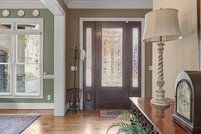 entryway with plenty of natural light, wood-type flooring, and ornamental molding