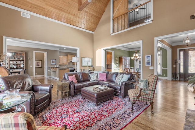 living room with light wood-type flooring, wood ceiling, crown molding, and high vaulted ceiling