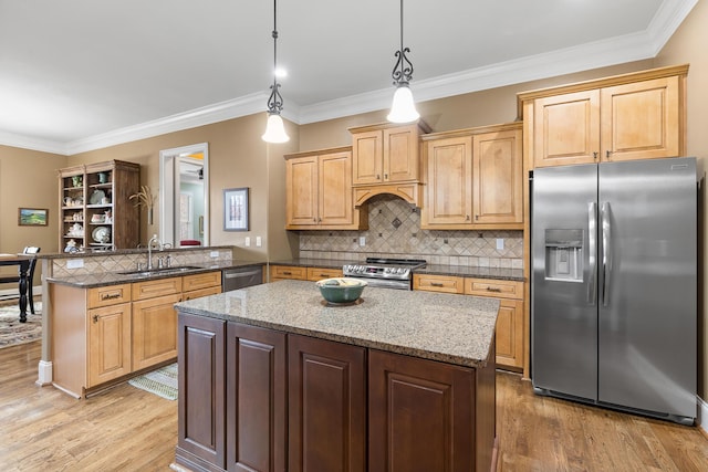 kitchen featuring pendant lighting, sink, light wood-type flooring, appliances with stainless steel finishes, and kitchen peninsula