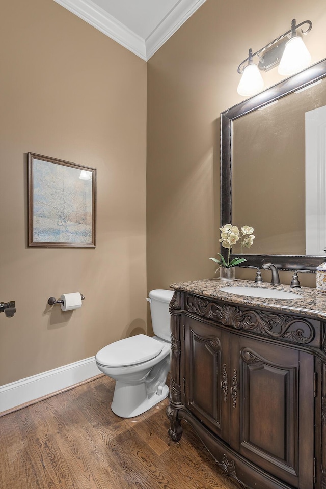 bathroom featuring hardwood / wood-style floors, vanity, toilet, and crown molding