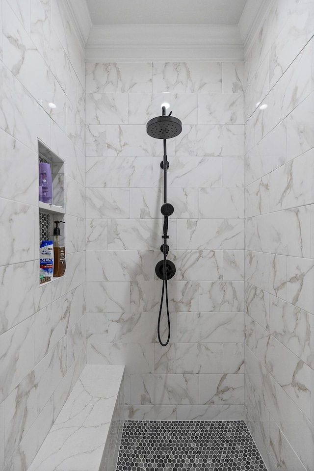 bathroom featuring tiled shower and ornamental molding