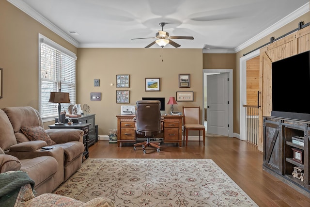 office area with ceiling fan, a barn door, dark hardwood / wood-style flooring, and crown molding