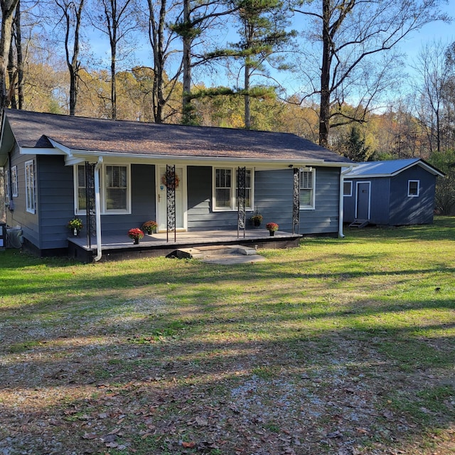 ranch-style home featuring a storage unit, covered porch, and a front lawn