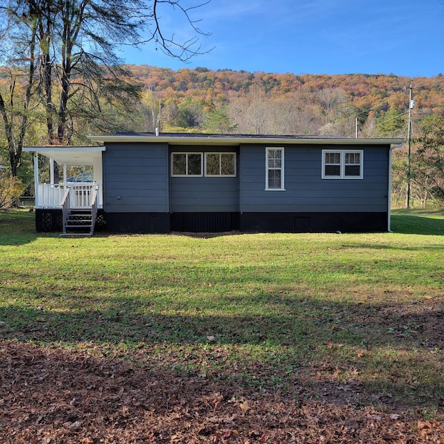 rear view of house featuring a yard