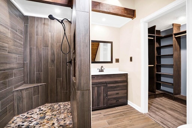 bathroom featuring vanity, wood-type flooring, and tiled shower