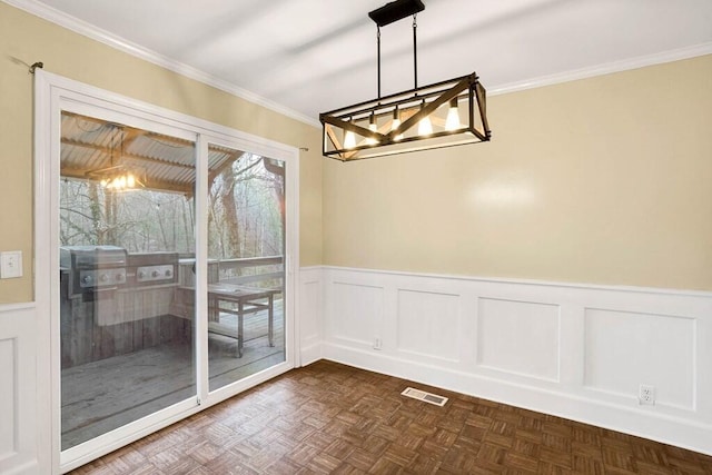 unfurnished dining area with dark parquet flooring and ornamental molding