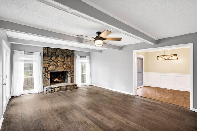 unfurnished living room with a healthy amount of sunlight, dark wood-type flooring, and a textured ceiling