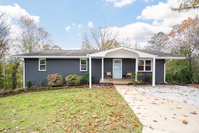 ranch-style house featuring covered porch and a front yard