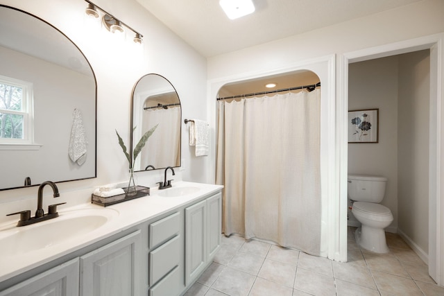 bathroom with tile patterned floors, vanity, toilet, and walk in shower