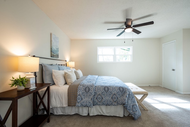 carpeted bedroom featuring a textured ceiling and ceiling fan