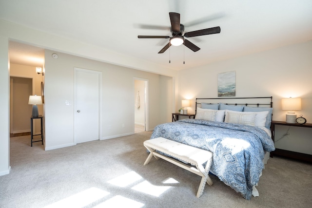 bedroom featuring ceiling fan, light colored carpet, and connected bathroom