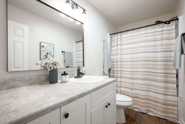 bathroom featuring vanity, wood-type flooring, and toilet