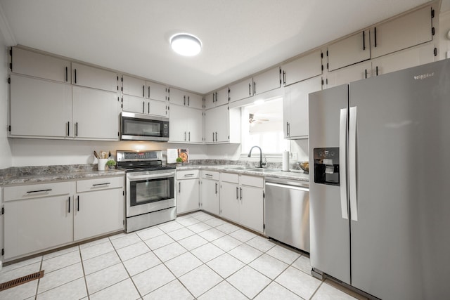 kitchen with white cabinetry, sink, light tile patterned floors, and stainless steel appliances