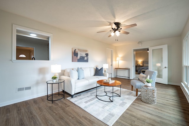 living room featuring hardwood / wood-style floors, ceiling fan, a textured ceiling, and french doors