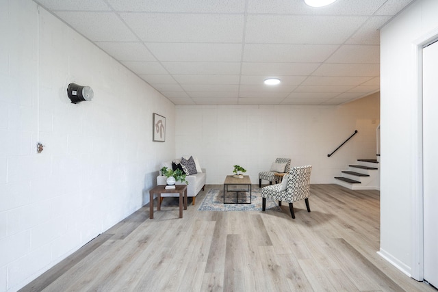 sitting room with a drop ceiling and light hardwood / wood-style flooring