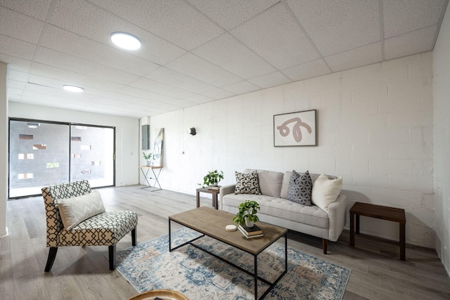 living room with a paneled ceiling and light wood-type flooring