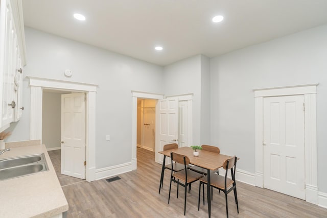 dining area with light wood finished floors, baseboards, and recessed lighting