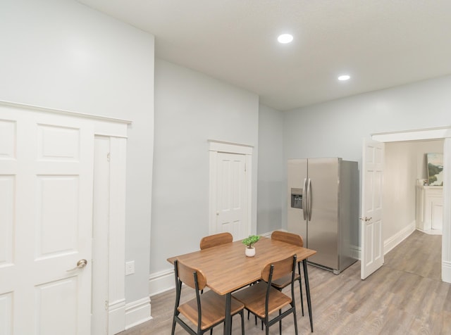 dining room with baseboards, light wood-type flooring, and recessed lighting